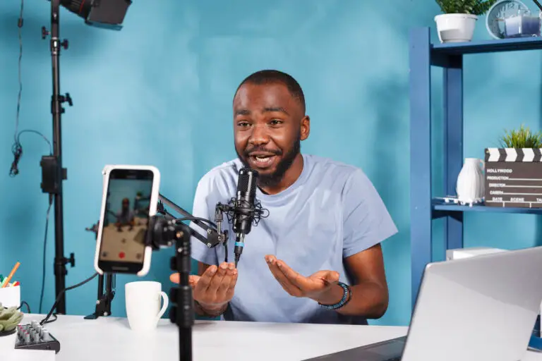 Un content creator registra un video usando uno smartphone e un microfono professionale